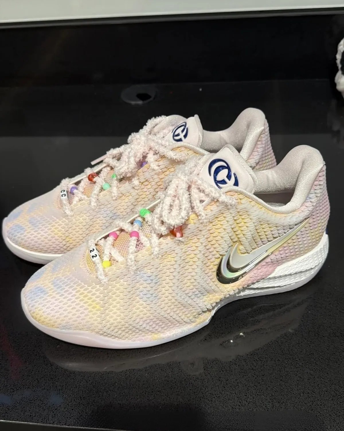 Nike Caitlin 1 'Friendship Bracelet' in Pearl Pink and Racer Blue with iridescent upper and charm-adorned laces, inspired by Taylor Swift's Eras Tour aesthetic - detail view 2