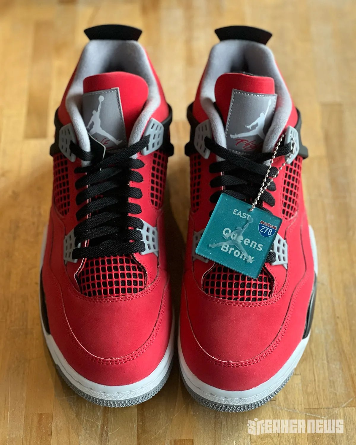 Air Jordan 4 "Toro Bravo" in red and black, shown from multiple angles alongside collectible hangtag featuring 278 Interstate and NYC borough graphics - detail view 1