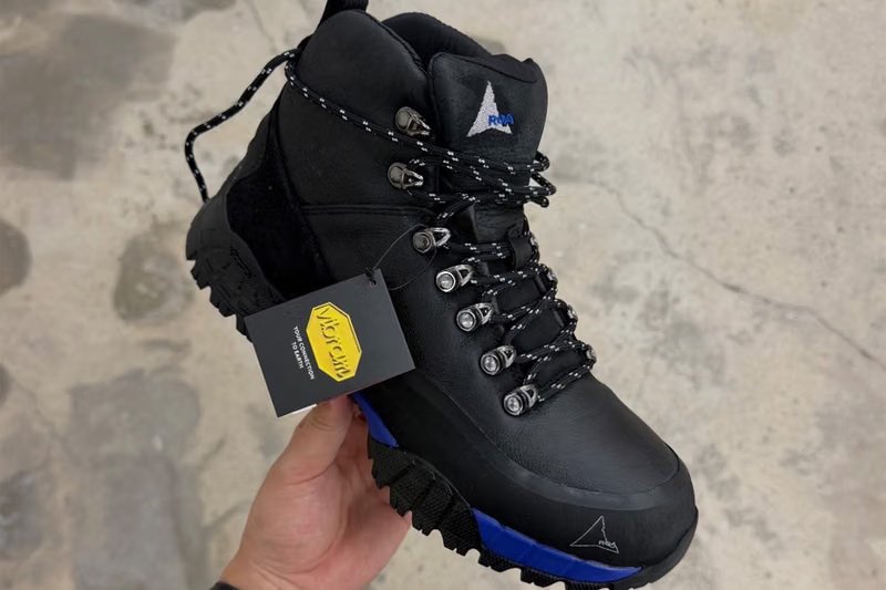 ROA x fragment design Andreas Boot side profile showing leather upper, Vibram sole, and metallic lace hooks - detail view 2