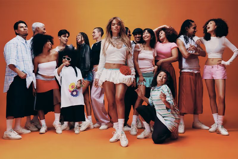 Karol G wearing Reebok Classics in the 'Born Classic. Worn Together.' campaign, shot in Mexico City with warm sunset tones reflecting her Tropicoqueta era - detail view 1