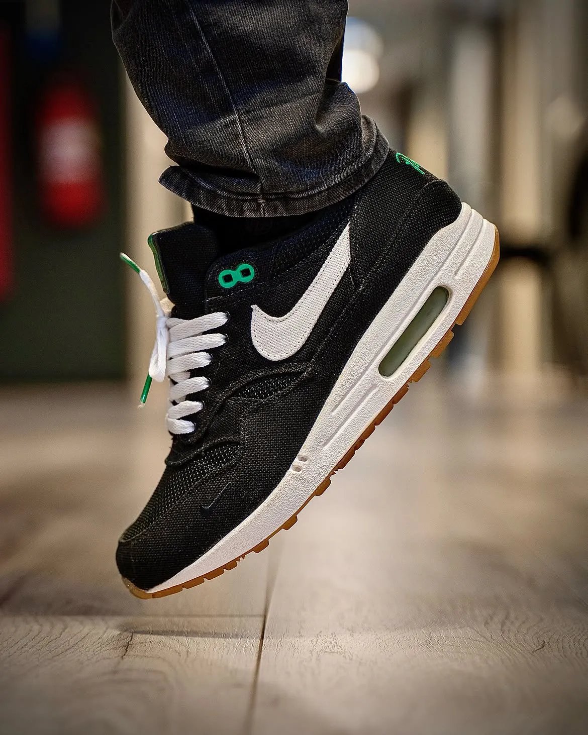 Patta x Nike Air Max 1 Lucky Green in black denim with bright green accents on eyelets and heel branding - detail view 3