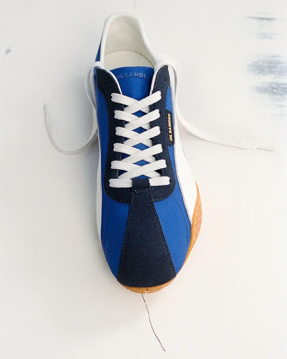 PUMA x Jil Sander K-Street sneaker in blue and navy colorway, showing low-profile sole and layered panel construction - detail view 4