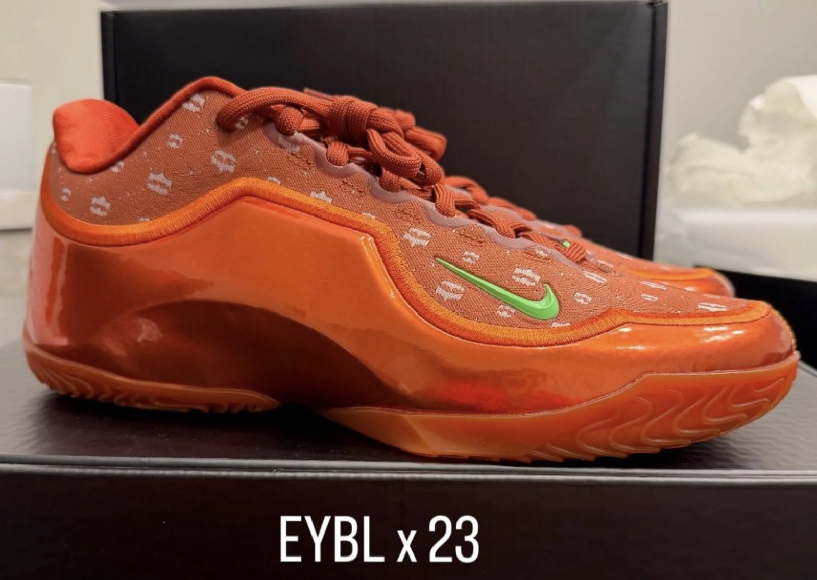 Nike LeBron 23 EYBL PE in orange with white crown graphics and green Swoosh detail - detail view 1