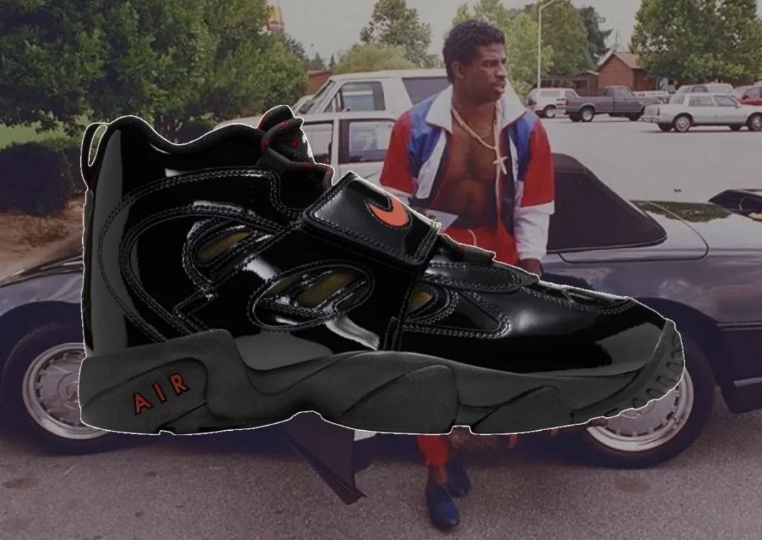 Nike Air Diamond Turf 2 in Patent Black with Gym Red and Metallic Gold accents, shown from lateral side view highlighting the glossy patent leather upper and midfoot strap