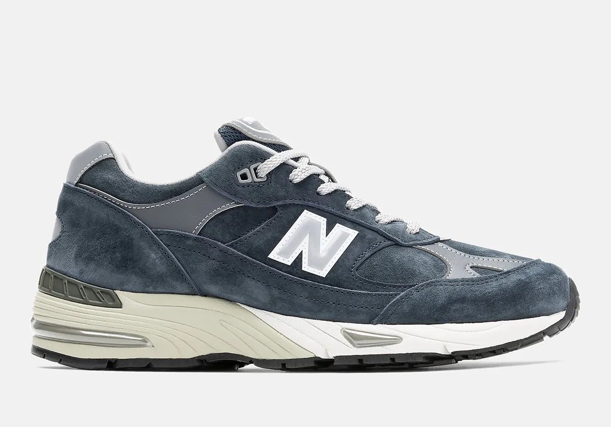 New Balance 991 Essential in black and navy colorways featuring premium nubuck uppers and white contrast sole units - detail view 1