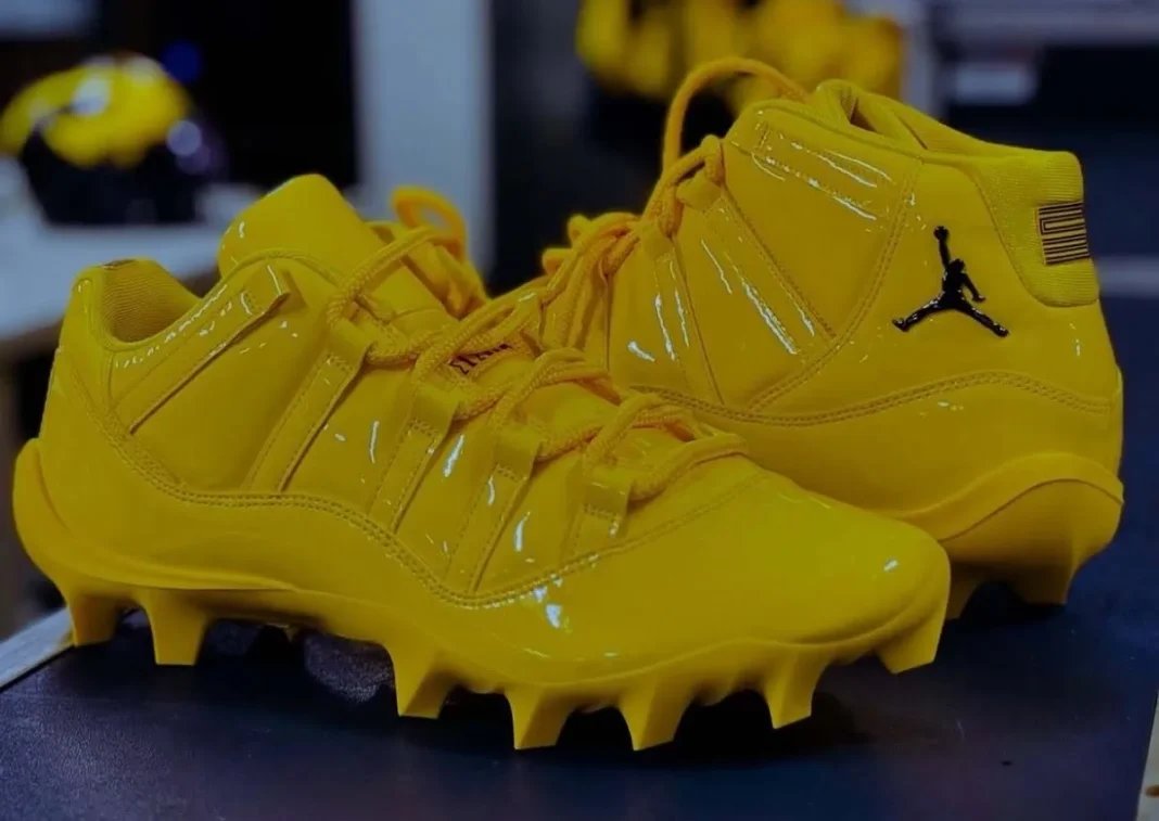 Michigan Air Jordan 11 cleat in maize yellow with black heel and ankle detailing, player-exclusive PE for Wolverines football - detail view 1