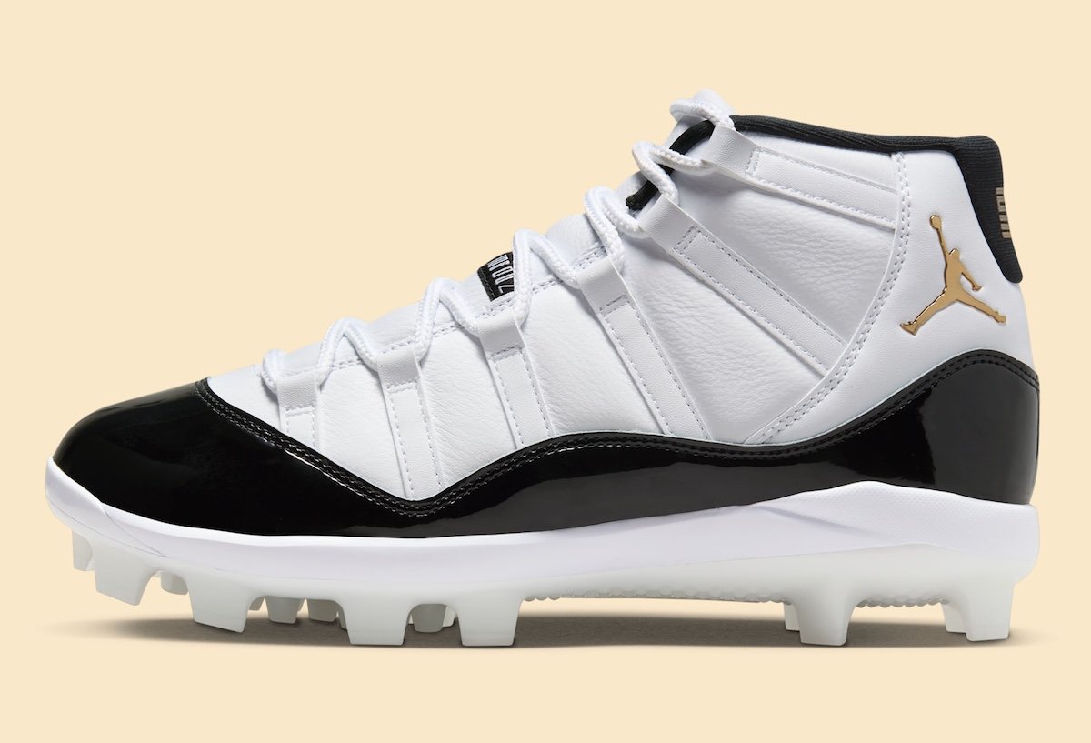 Air Jordan 11 MCS Cleat DMP in white leather with black patent mudguard and metallic gold details, shown with off-white cleated outsole for baseball performance - detail view 3