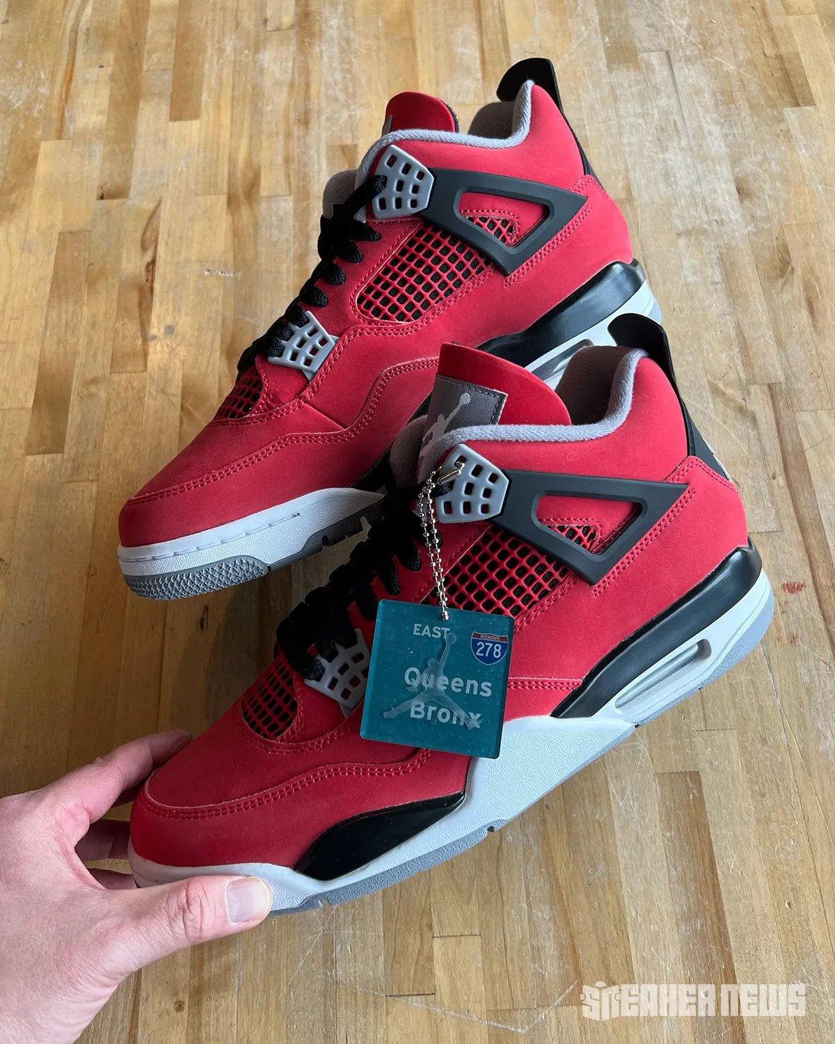 Air Jordan 4 "Toro Bravo" in red and black, shown from multiple angles alongside collectible hangtag featuring 278 Interstate and NYC borough graphics - detail view 2