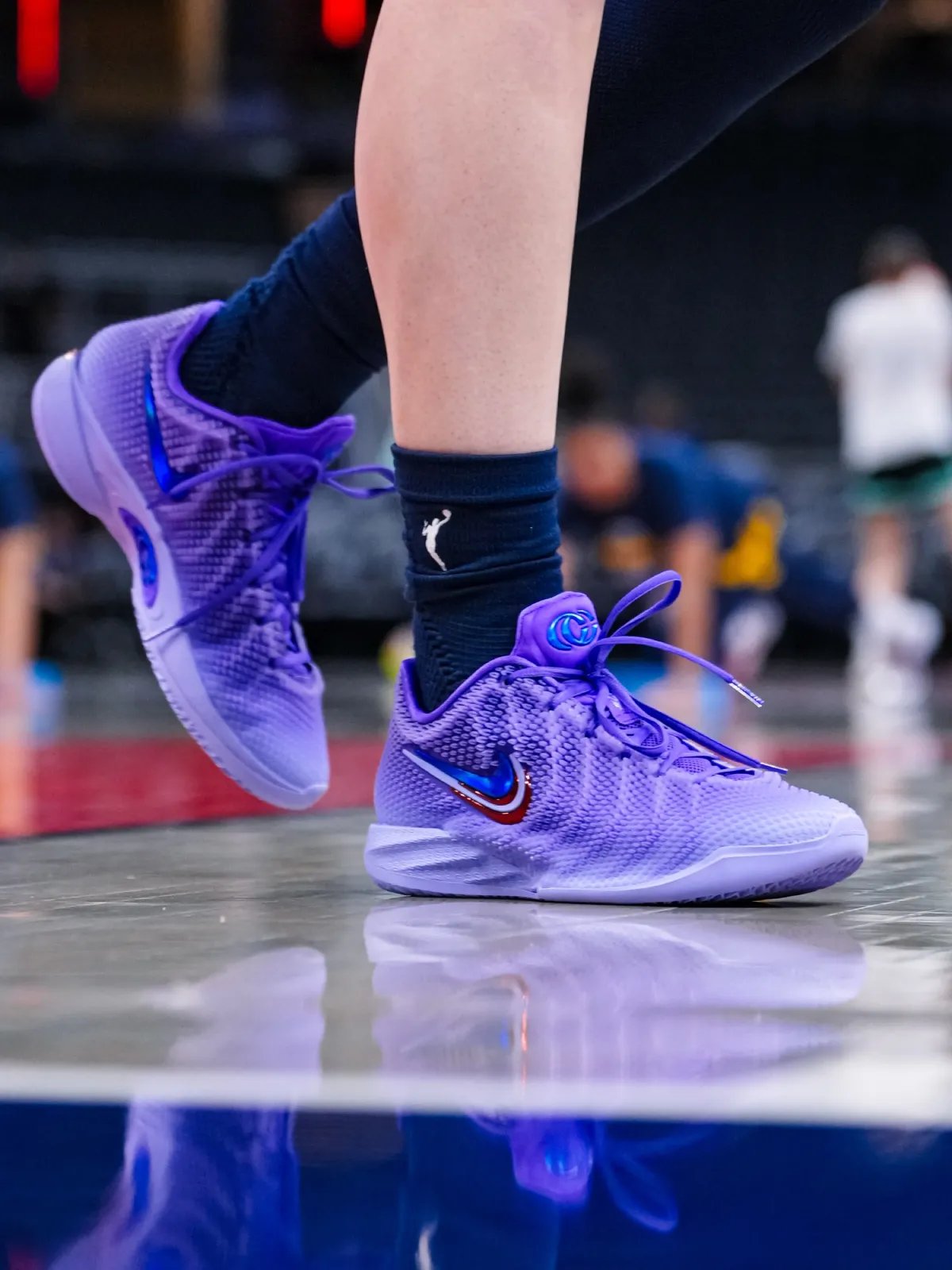 Caitlin Clark wearing the Nike Caitlin 1 in lavender purple with layered Swoosh details during WNBA game - detail view 3